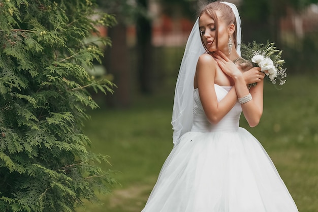 Hermosa Novia En Un Magnífico Vestido De Novia Posando Entre Vegetación En La Calle Chica Posa 1450