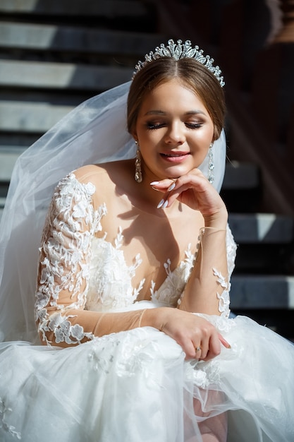 Hermosa Novia Con Un Vestido De Novia Blanco Se Sienta En Los Escalones Y Sonríe 4437