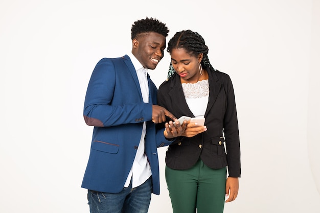 Hermosos jóvenes africanos sobre un fondo blanco con teléfonos en las manos Foto Premium 