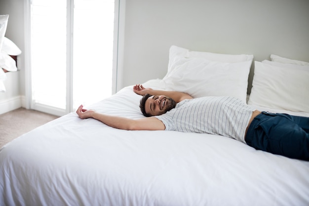 Hombre Acostado En La Cama Con Los Brazos Arriba En La Cama En El ...