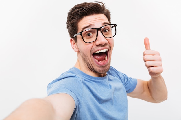 Hombre Alegre En Camiseta Y Anteojos Haciendo Selfie Y Mostrando El Pulgar Hacia Arriba Mientras