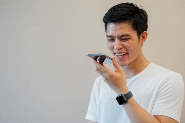 Hombre asiático con smartphone para hablar por reconocimiento de voz Foto Premium 