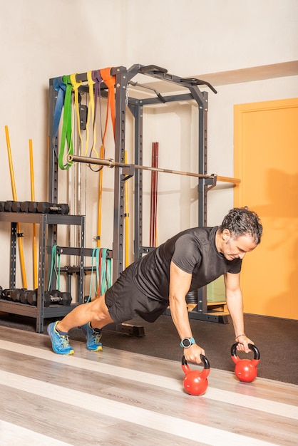 Hombre Atleta Haciendo Ejercicio De Flexiones Con Pesas Rusas En El