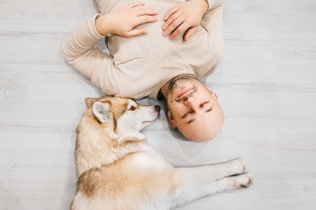 Hombre Calvo Adulto Con Cachorro Husky Durmiendo En El Piso