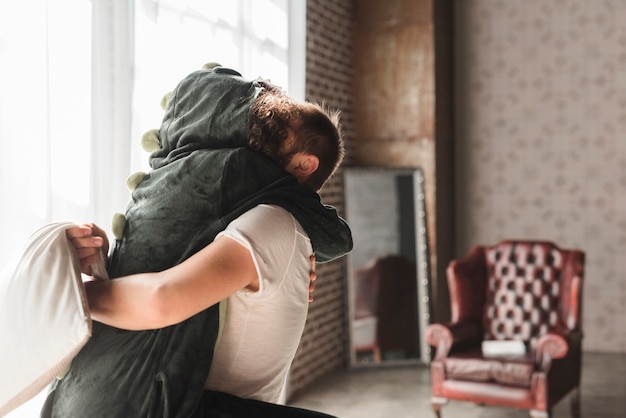 Hombre Cargando A Su Novia Besándose En La Habitación Foto Gratis 5280