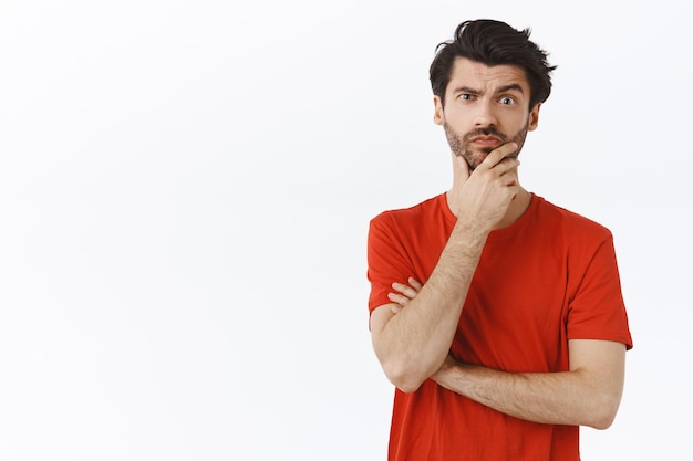 Hombre con cerdas frotándose la barba y sonriendo mientras fruncía el