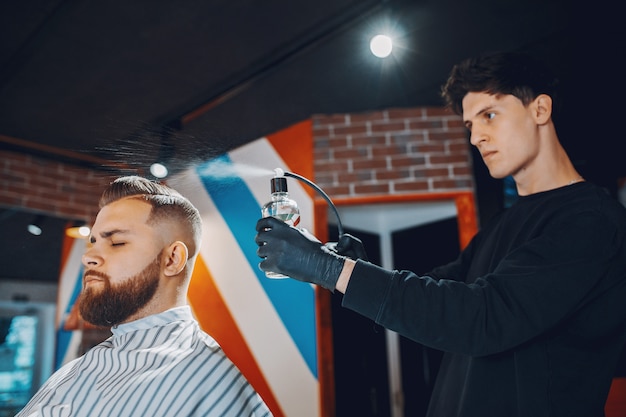 Hombre elegante sentado en una barbería Foto gratis