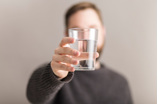 Hombre enseñando vaso de agua Foto gratis