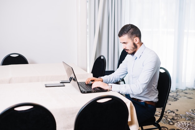 Hombre Escribiendo En La Computadora Portátil En La Oficina Foto Gratis