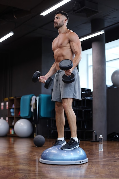 Hombre En Forma Y Musculoso Trabajando Con Bumbbells En Bola Bosu De ...