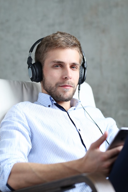 Hombre Guapo Escuchando Podcast En Auriculares | Foto Gratis