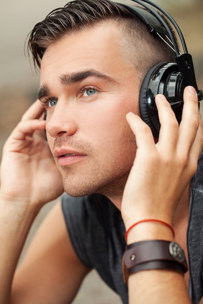 Hombre Guapo Sentado En La Calle Con Auriculares Foto Gratis 9587