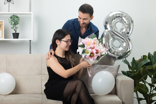 Hombre Guapo Sonriente Dando Ramo De Flores A Una Mujer Joven Y Bonita