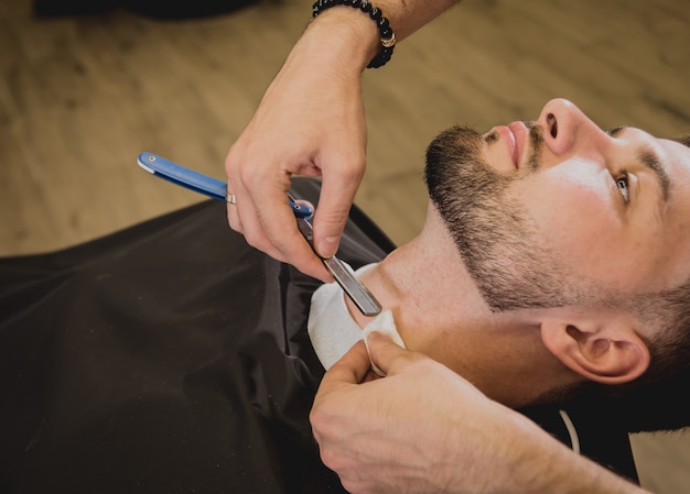 Hombre joven con corte de pelo de moda en peluquería ...