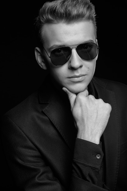 Hombre Joven Con Gafas Negras En Una Chaqueta Negra Sobre Negro Blanco Y Negro Photo Foto Premium