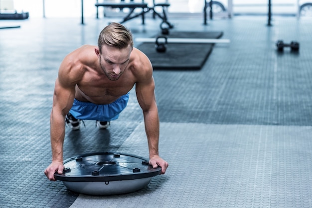 Hombre Musculoso Haciendo Ejercicios De Pelota Bosu | Foto Premium