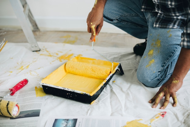 Hombre pintando las paredes amarillas. Foto gratis