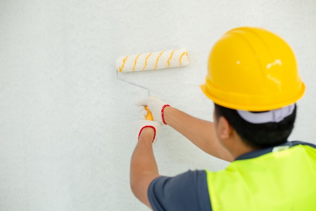 Hombre Pintor En El Trabajo Con Un Rodillo De Pintura En La Pared