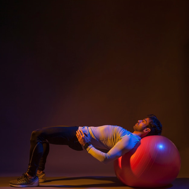 Hombre que ejercita en fitball Foto gratis