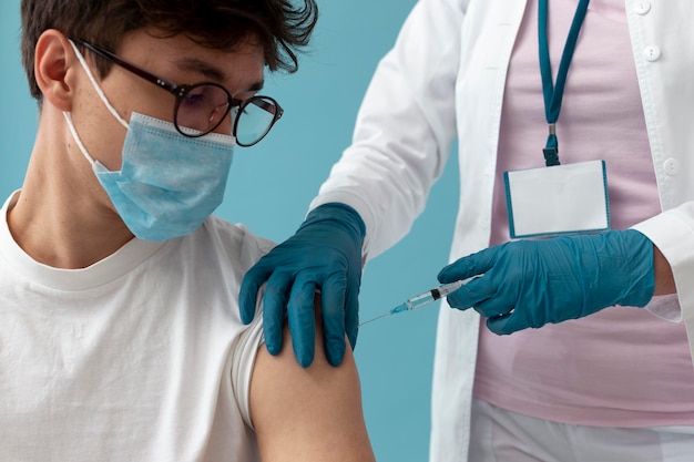 Hombre recibiendo la vacuna de cerca Foto gratis