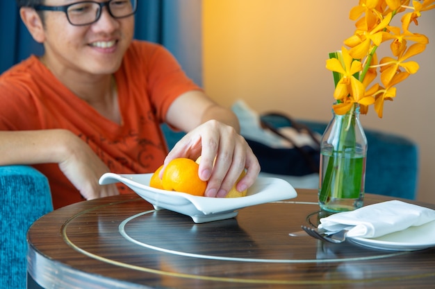 Hombre Recoger Naranja Del Plato Concepto De Fruta Saludable Foto Premium