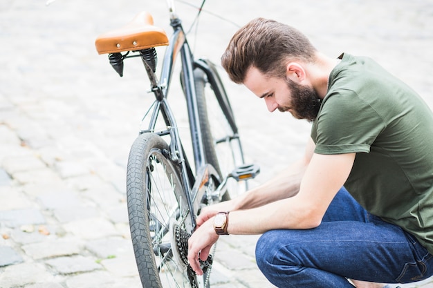 Hombre reparando su bicicleta | Foto Gratis