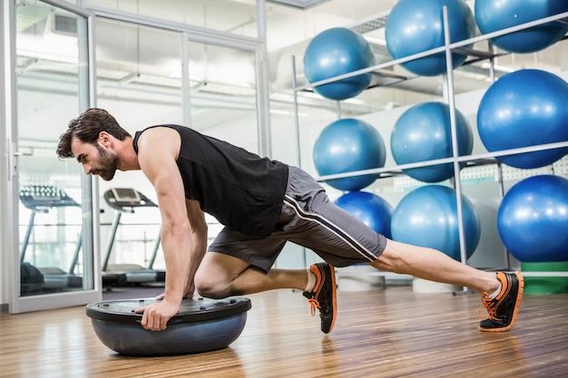 Hombre Serio Que Hace Ejercicio Con La Bola De Bosu En El Estudio ...