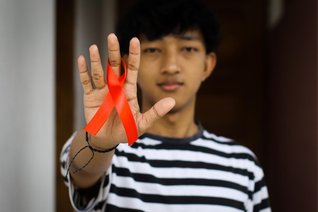 Hombre Sujetando Una Cinta Roja Que Muestra Su Apoyo A La Concienciación Sobre El Sida Foto 6679