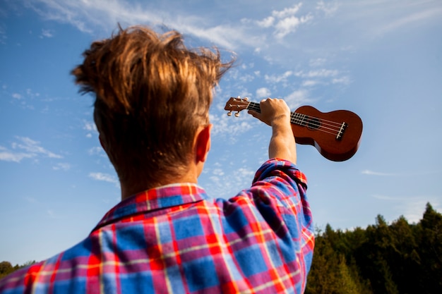 Hombre Sujetando Su Guitarra Ukelele En El Aire Foto Gratis