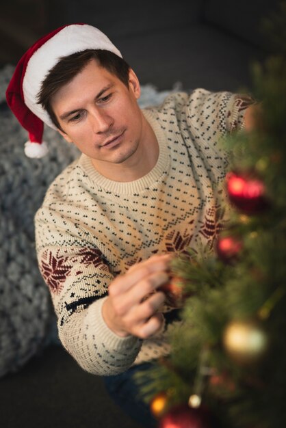 Tout(e) seul(e) à la maison pour Noël ? Hombre-vestido-sombrero-santa-decorando-arbol-navidad_23-2148336650