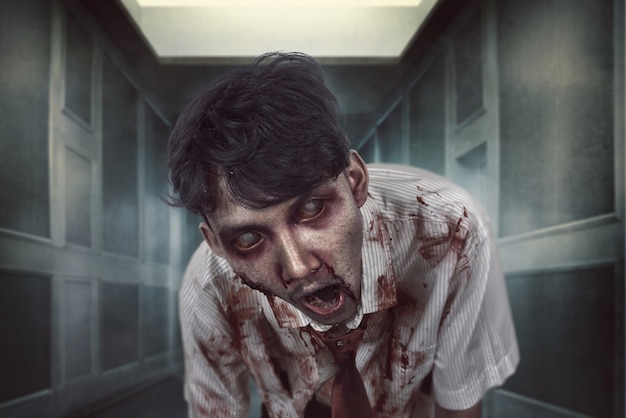Hombre zombie espeluznante con rostro sangriento en el lugar oscuro Foto Premium