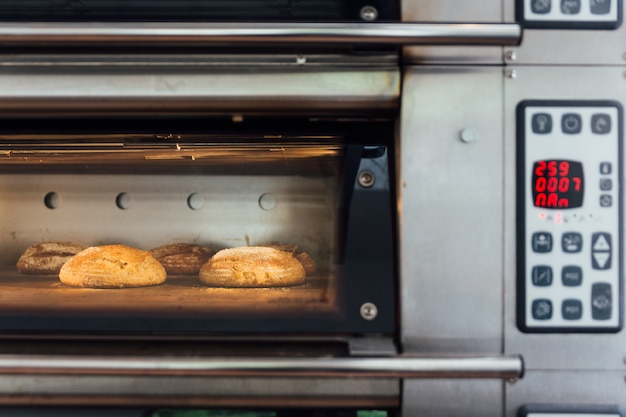 firma Oficial sabor dulce Horneado de pan casero en horno eléctrico. producción de horno en la  panadería. cocinando pan. | Foto Premium