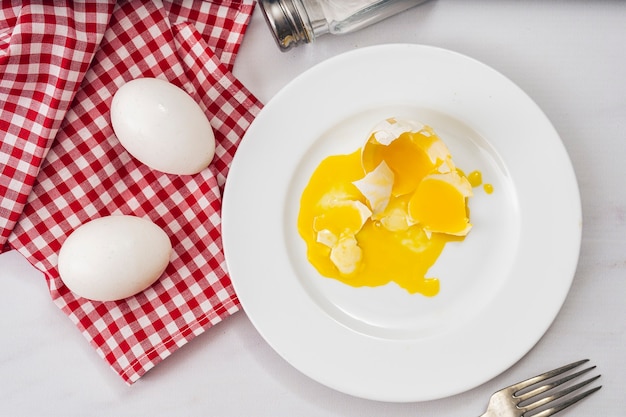 Huevo De Gallina Roto En Un Plato Blanco Junto A Dos Huevos Saludables