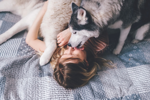 Husky Cachorro Lamiendo La Cara De Su Due A Foto Premium