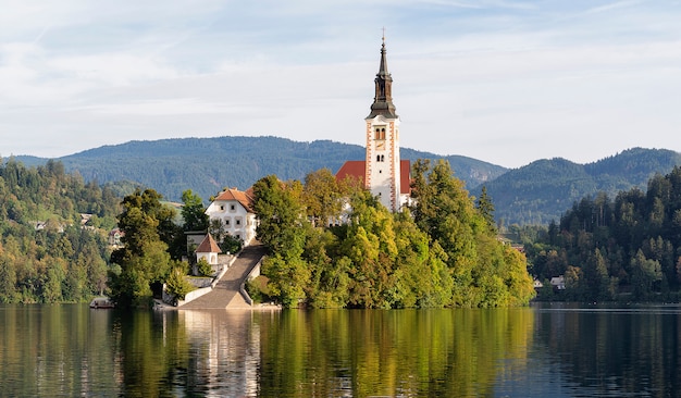 Iglesia De La Asuncion De Maria En La Isla Del Lago Bled Eslovenia Con Reflejos En El Agua Foto Premium