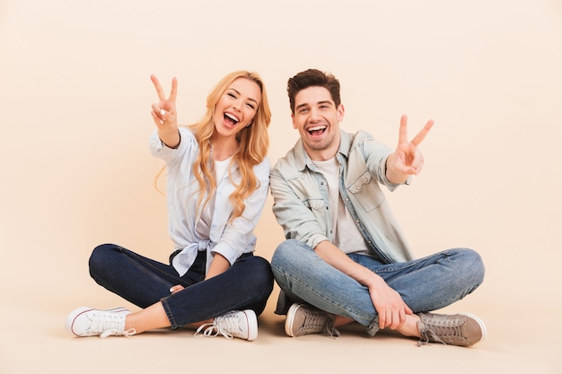 Imagen De Dos Amigos Felices Hombre Y Mujer En Ropa Casual Sentados En El Suelo Con Las 6514