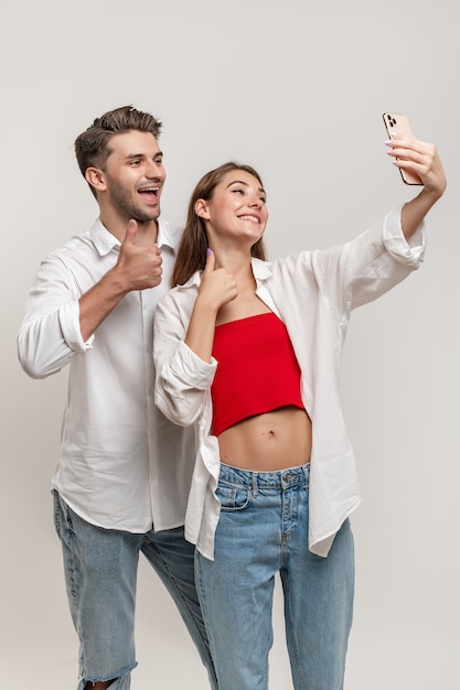 Imagen De Pareja Emocionada Mostrando Los Pulgares Hacia Arriba Mientras Toma Selfie Aislado 