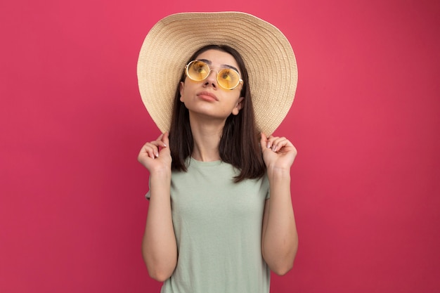 Impresionada joven bastante caucásica vestida con sombrero de playa y