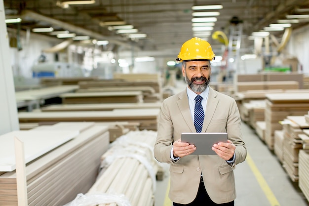 Ingeniero maduro guapo en la fábrica con tableta digital Foto Premium