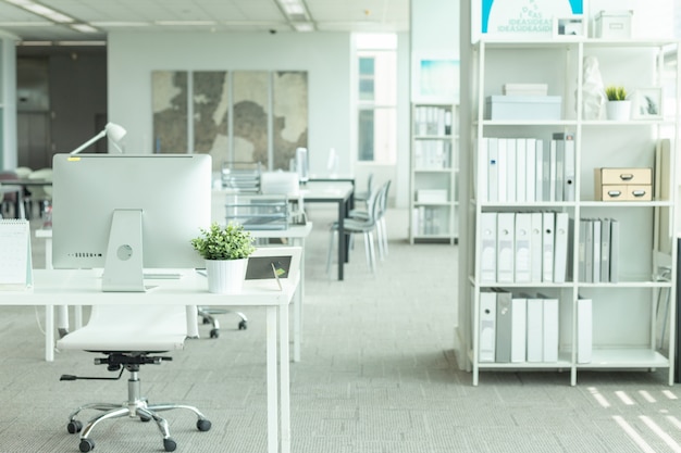 Interior de una oficina moderna con computadora y muebles blancos. Foto Premium