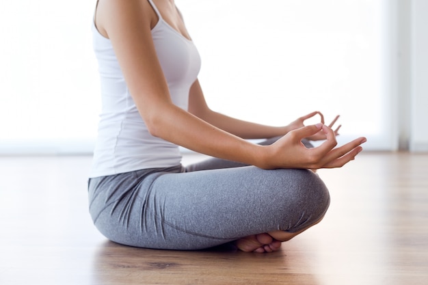 Joven Y Bella Mujer Haciendo Ejercicios De Yoga En Casa Foto Premium