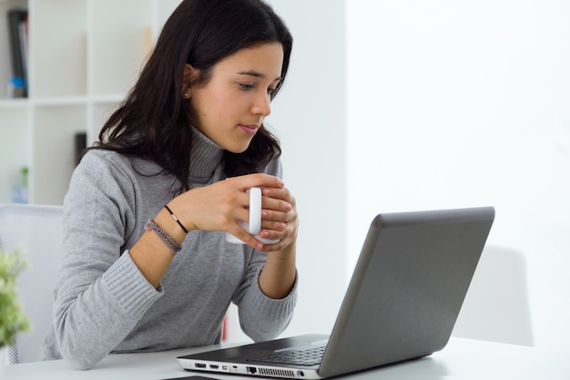 Joven y bella mujer usando su computadora portátil en casa. | Foto ...