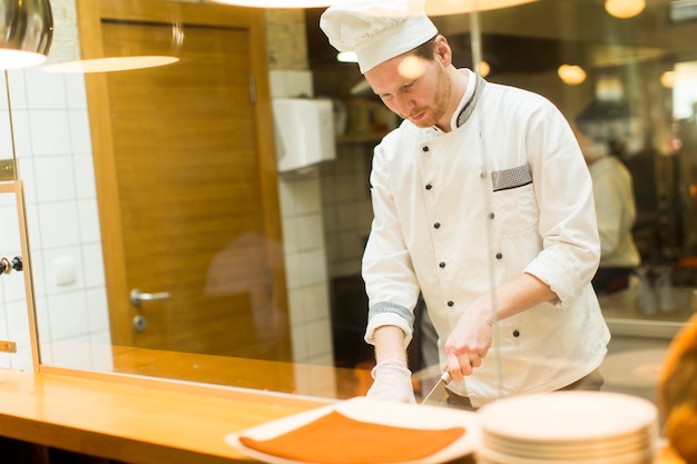 Joven Chef Preparando Comida En La Cocina Foto Premium 