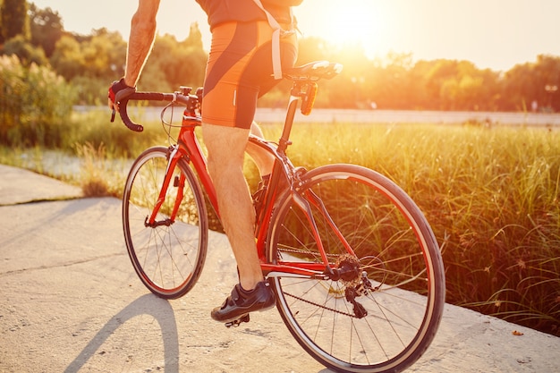 Joven está ciclismo bicicleta de carretera en la noche | Foto Gratis