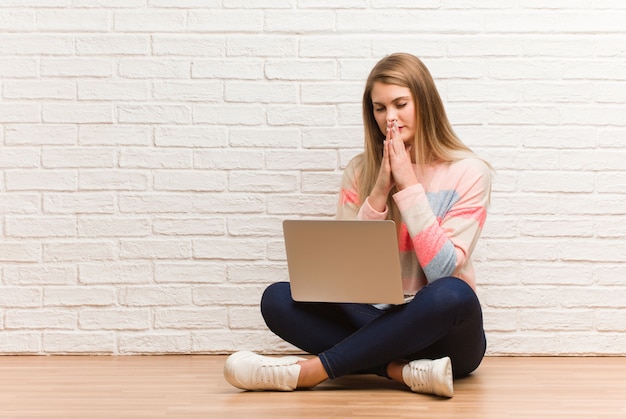 Joven estudiante rusa mujer sentada rezando muy feliz y confiada Foto Premium