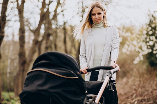 Joven Madre Caminando Con Carro De Bebé En El Parque | Foto Gratis