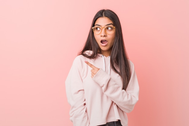 Joven Mujer Arabe Bonita Con Un Look Deportivo Casual Apuntando Hacia El Lado Foto Premium