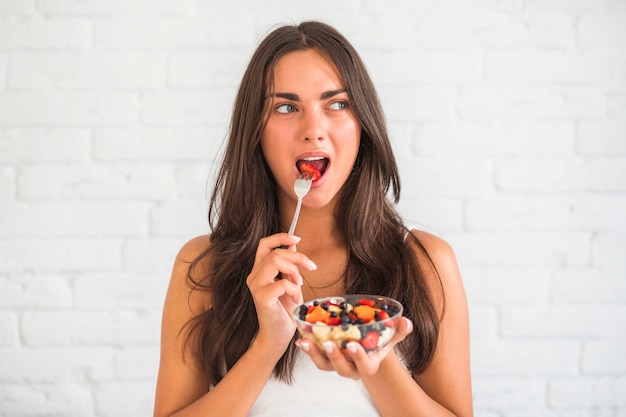 Joven Mujer Comiendo Ensalada De Frutas Con Tenedor Foto Gratis 9752