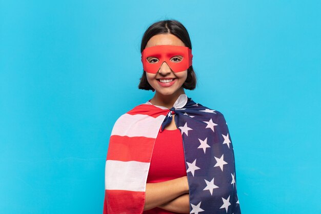 Joven mujer latina sonriendo con los brazos cruzados y una expresión