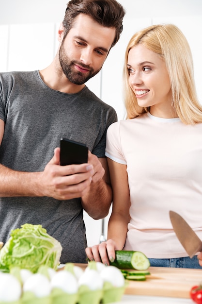 Joven Pareja Amorosa Feliz Cocinando Juntos Usando El Teléfono Foto Gratis 5648